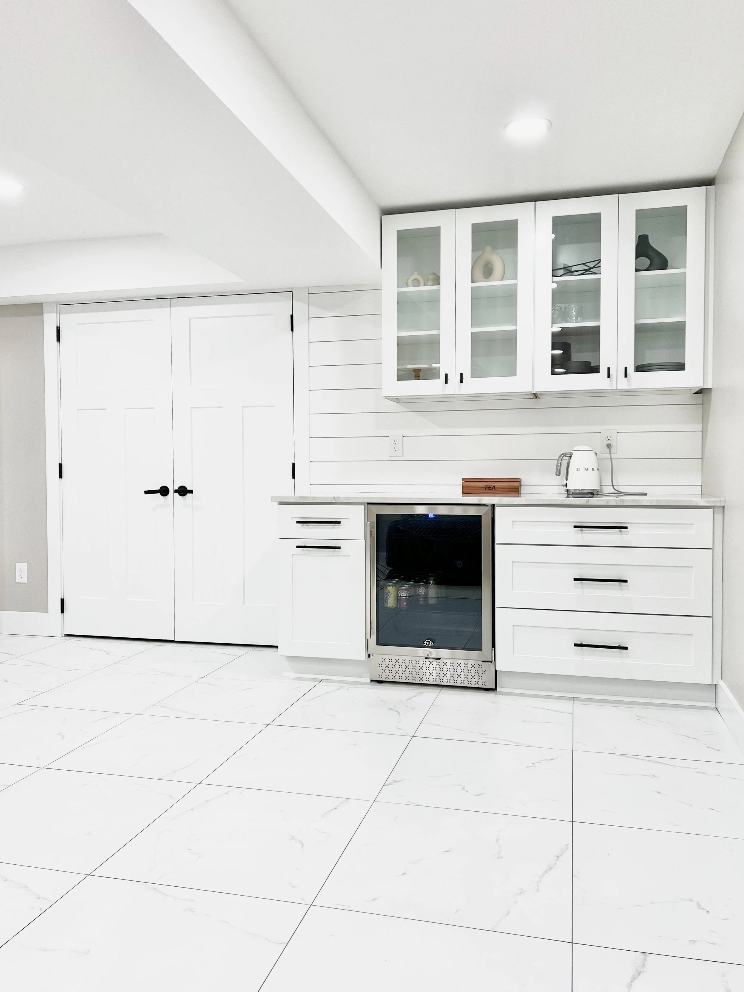 Finished basement with built-in shelving, recessed lighting and a seating area